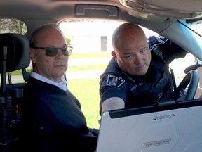 BRUCE BELL/The Intelligencer
Const. Brad Stitt of Belleville Police Service shows Mark Hanley how automated license plate recognition software (ALPRS) in a one of the force’s vehicles works. Hanley was part of a group of local businessmen who purchased the software for the local police force.