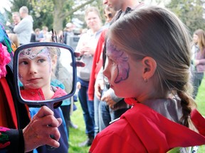 Alanah Tschudi, 8, looks at her reflection in a mirror after her face was painted with a unicorn image last Saturday, May 12 during the 17th annual Mitchell Kinettes’ Rubber Duck race. ANDY BADER/MITCHELL ADVOCATE