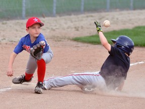 Stretching for the ball for a potential out at third base was Nate Uniac (left) of the Mitchell Rookie (Brown) baseball team last Wednesday, May 9 during exhibition action against visiting London. The higher-ranked visitors defeated the Astros, 22-6. ANDY BADER/MITCHELL ADVOCATE