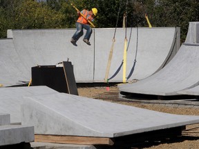 Crews move large cement components into place as they
construct a skateboard park.