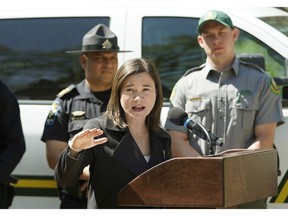 Shannon Phillips (Alberta Environment and Parks Minister, at podium) announced enforcement on public land and parks over the May long weekend and throughout the summer. In background are Kanwarjit Ghumman (left, Traffic Sheriff) and Austin Toly (right, Conservation Officer). Larry Wong/Postmedia Network