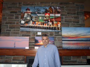 Pictured is Oakwood Resort co-owner John Labatt Scatcherd who set up his art studio at Oakwood Resort as part of the Grand Bend and Area Studio Tour on May 6. Scatcherd took up photography two years ago when his father was ill and gave him a camera for Christmas. Scatcherd has been taking pictures of the Grand Bend shoreline ever since and says it makes him feel closer to his late father.  Pictured behind Scatcherd is one of his pieces that he sold called “Dock Life.” (William Proulx/Exeter Lakeshore Times-Advance)