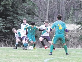 Canmore Collegiate's Kota Postma eludes a pair of Holy Trinity Academy defenders during a senior boys high school soccer game on May 9 at Millennium Park. The Canmore Crusaders tied the Okotoks-based Knights 2-2 in the Foothills High School Soccer League contest.