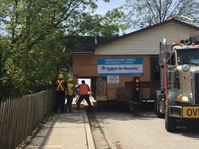 Workers move quickly to remove a tree branch on Skye Street in Ingersoll as a Habitat for Humanity Home is transported from London to Ingersoll on Wednesday. (HEATHER RIVERS/SENTINEL-REVIEW)