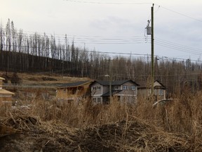 A lot that was once the site of a home in Waterways is covered in grass, as homes are rebuilt in the background on Monday, April 30, 2018. Vincent McDermott/Fort McMurray Today/Postmedia Network