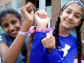 Grade 7 students Harini Satheeskumar and Maheen Inayat show off the bracelets they were selling at a social enterprise flea market hosted at Masonville public school. The pair and their peers donated proceeds to Because I Am a Girl. (Chris Montanini\Londoner)
