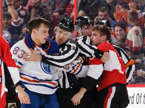 Chris Wideman of the Ottawa Senators and Matthew Benning the Edmonton Oilers are separated by linesman Devin Berg (87) and linesman Brad Kovachik after exchanging punches at Canadian Tire Centre on Jan. 8, 2017 in Ottawa. (Jana Chytilova/Freestyle Photography/Getty Images)