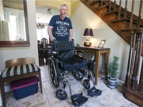 Jon Weinstein rolls his daughter Annie's wheelchair through their home in Beaconsfield, Que., on Monday. Annie, 16, suffers from chronic Lyme disease. (John Mahoney / Postmedia)