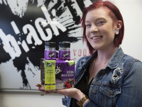 Black Fly Beverage Co. sales and marketing support administrator Charlotte Gooding displays their mixed berry vodka coolers that come with a one-time-use breathalyzer for a limited time. (Derek Ruttan/Postmedia Network)
