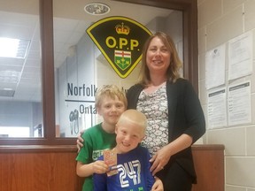 Two brothers from Simcoe, Nathan Leigh, 8, and Adam Leigh, 5, presented candy and $50 to Norfolk OPP Sgt. Lisa Lambert to be donated to a local teen who was assaulted and had his bicycle stolen during a recent incident along the Lynn Valley Trail.    Norfolk OPP/Twitter Photo