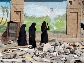 Yemeni women take pictures of the damage following an air-strike carried out by the Saudi-led coalition on a school and a bowling club, in the capital Sanaa, on February 12, 2016.   / AFP / MOHAMMED HUWAISMOHAMMED HUWAIS/AFP/Getty Images
