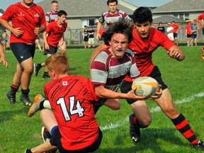 Mauthe Cup
Holy Trinity's Jason Jones looks to make a pass while being tackled during the NSSAA boys rugby championship Thursday in Simcoe. The Titans won their first Mauthe Cup title since 2007 by a score of 17-14 over Waterford.
JACOB ROBINSON/Simcoe Reformer