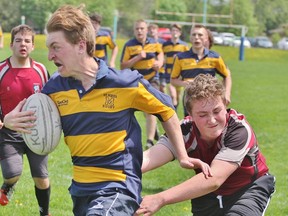 St. Michael's Hunter Sawitzky tries to outrun the tackle of Northwestern's Jayden Schweitzer during the Huron-Perth junior boys rugby game Friday at St. Mike's. (Cory Smith/The Beacon Herald)