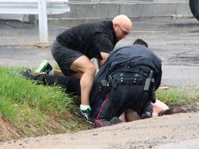 Andy Gagne, a principal with the Near North District School Board, helps North Bay Police Const. Richard Hampel take down and handcuff a suspect near the Algonquin and Greenwood avenue intersection Saturday afternoon. Dave Dale / The Nugget