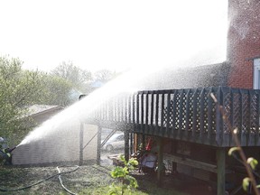 A Greater Sudbury firefighter sprays water on a section of an apartment fire on College Street in Sudbury, Ont. on Friday May 18, 2018. John Lappa/Sudbury Star/Postmedia Network