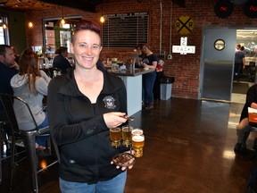 Morag Kloeze, owner and brewmaster at Mudtown Station brewpub and restaurant in Owen Sound, holds a flat of craft beers in the bar area of the newly-opened business. The business is located in the former Canadian Pacific Railway on Owen Sound's east harbour. (Rob Gowan The Sun Times)