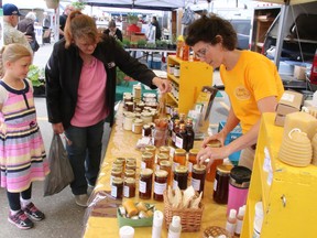 Jaimie Board, of Board's Honey Farm in Restoule, serves customers at the North Bay Farmers' Market, Saturday. Dave Dale / The Nugget