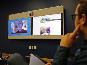 Jeff Wieland, right, Facebook director of accessibility, watches as engineer Matt King, who is blind, demonstrates facial recognition technology via a teleconference at Facebook headquarters in Menlo Park, Calif., on December 18, 2017. Based on recent announcements by the likes of Facebook, Live Nation and a U.K. police force, Canadians may need to get used to the idea of facial recognition technology permeating their everyday lives. THE CANADIAN PRESS/AP, Eric Risberg