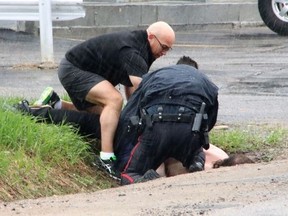 Andy Gagne, a principal with the Near North District School Board, helps North Bay Police Const. Richard Hampel take down and handcuff a suspect near the Algonquin and Greenwood avenue intersection Saturday afternoon. Dave Dale / The Nugget