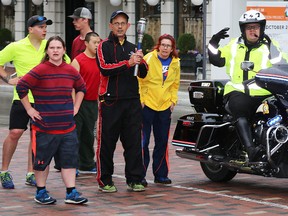 TIM MEEKS/THE INTELLIGENCER
Torch bearer John Tinney waits for the lights to change at the intersection of Bridge and Pinnacle Streets in downtown Belleville Tuesday for the Law Enforcement Torch Run for Special Olympics Ontario.