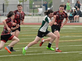 Tommy Gemmell of St. John's College sprints past several Paris District High School players on his way to a try Tuesday during the Brant County high school senior boys rugby semifinals at the Bisons Alumni North Park Sports Complex. (Brian Smiley/The Expositor)