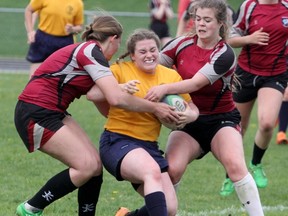 St. Mike’s Sarah Bailey tries to break a pair of tackles from Northwestern’s Brandy Bundscho, left, and Savannah Hoover during the Huron-Perth girls rugby semifinal Tuesday in Clinton. St. Mike’s won 42-0 and went on to win gold. Cory Smith/The Beacon Herald