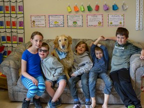 Ellie Roblin (left to right), her brother Gage, Elisha Neill, Aiden Dunlop and Bryson Somerset pose with Ralph McCall School's therapy dog Hudson. Hudson has been certified by Chestermere Therapy Dogs Society to help children in the school relax and manage their emotions in a fun way.