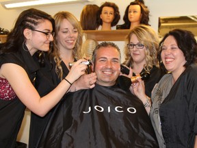 Collège Boréal president Daniel Giroux got a haircut and primping from a team of graduates of the two-year hairdressing program offered at the Timmins campus. The students, from left, Joelle Gervais, Shana Montreuil, Mélanie Viau and Martine Cloutier, were among 41 Collège Boréal graduates who were presented with their diplomas at a ceremony at the Timmins campus Wednesday night.