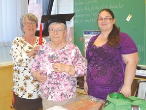 Photo by KEVIN McSHEFFREY/THE STANDARD
Continuing education teacher at the Adult Education Centre in Elliot Lake Jody Wilson helps her oldest student, 73-year-old Lynn Landriault with her mortarboard in preparation for her graduation. She was assisted by Brittany Boudreau another student in the program.