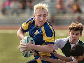 Aiden Vachon of Brantford Collegiate Institute looks for a teammate to pass to as a pair of St. John's College attackers latch on for a tackle during the Brant County high schools junior boys rugby championship game on Thursday. (Brian Thompson/The Expositor)