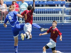 Julia McKay/The Whig-Standard
Kingston Blues’ Marcus Vingerhoeds jumps to block the ball from Regiopolis Notre-Dame Panthers’ Malinga Zablocki and Matt Mulholland during the second half of the Kingston Area Secondary Schools Athletic Association senior boys soccer final at Richardson Stadium on Thursday. The Panthers won, 1-0.