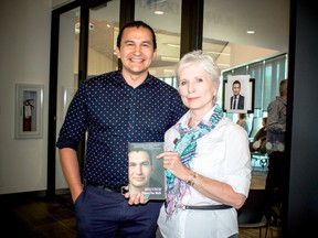 Berry displays Kinew's book as they stand together outside the theatre at Gaynor Family Library on May 25.