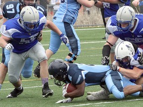 Sudbury Gladiators' Sam Sirkka (34) gets hold of Toronto Junior Argos' Cazzie Shallow (2) while Matthew England (55) and Mike Andlar (56) rush in to help during Ontario Football Conference varsity action at James Jerome Sports Complex in Sudbury, Ont., on Saturday, May 26, 2018. Ben Leeson/The Sudbury Star/Postmedis Network