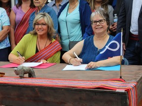 Sandra Jansen, Alberta Infrastructure Minister, and Gail Gallupe, president of McMurray Métis, sign an agreement transferring provincial land to the McMurray Métis on Friday, May 25, 2018. Vincent McDermott/Fort McMurray Today/Postmedia Network
