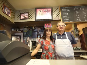 Bill and Marina Kosmopoulos are seen behind the counter at La Pizzeria in Napanee, surrounded by their Avril Lavigne memorabilia. La Pizzeria is famously the pop star’s favourite pizza place, and she still visits when she’s in town. (Meghan Balogh/The Whig-Standard/Postmedia Network)