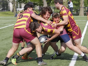 Regiopolis-Notre Dame Panthers' Will Kennedy, centre, with the help of teammates Sebastian Alamillo and John Sherboneau, tries to keep the ball inbound against the La Salle Black Knights' Elijah Fitzgerald and Dan Hammond during the second half of the Kingston Area Secondary Schools Athletic Associations senior boys rugby final at Nixon Field, in Kingston, Ont., on Friday, May 25, 2018. The Panthers won 22-19 over the Black Knights. (Julia McKay/The Whig-Standard/Postmedia Network)