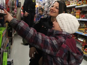 Const. Emily Coccimiglio, of Sault Ste. Marie Police Service, shops with Shaelyn Levesque, 8, during the eighth annual Shop with a Cop at Walmart on Great Northern Road in Sault Ste. Marie, Ont., on Saturday, Dec. 19, 2015.