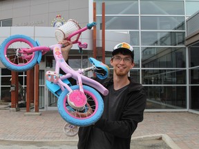 Seth Walton holds up the kids bike which he got for a "steal of a deal" at the Timmins Police Service's annual property auction Saturday morning. Walton said he bought it for his niece who is turning two.