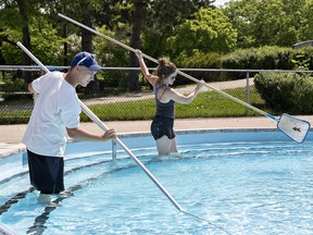 Lifeguards Jaden Dilba and Andrea Rideout skim the pool at Earl Haig Family Fun Park on Monday  as temperatures soared above 30C. The park will open for the season on June 1 at noon. (Brian Thompson/The Expositor)