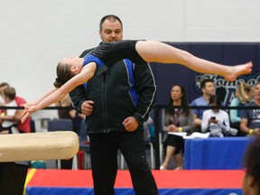 Gymtrix coach Marc Pilon watches as Keala Wright, 9, vaults at the 20th annual Gymtrix Sunshine Classic at Nipissing University's Robert J. Surtees Athletic Centre, Sunday. Dave Dale / The Nugget