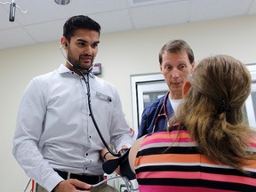 First-year medical student Akash Verma, left, and Dr. Phil Schieldrop take a person’s blood pressure at Stratford General Hospital on Tuesday, May 29, 2018 in Stratford, Ont. (Terry Bridge/Stratford Beacon Herald)
