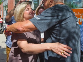 NDP Leader Andrea Horwath was campaigning at the headquarters of candidate Michael O'Brien in Stratford on Tuesday. She was about to leave town when she unexpectedly exited the bus to greet a late arriving admirer - former premier David Peterson.  Peterson was in town to see a play and decided to say hello when he spotted Horwath's bus. (Derek Ruttan/Postmedia Network)