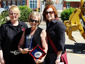 Cheryl Kimble receives the Stomper of the Year Award, presented by Stompede board treasurer Bernie Benson (left) and past president Terri Sudnik, during the Stompede Bust Out Barbecue at Revolution Place on Tuesday May 29, 2018 in Grande Prairie, Alta. 
Kevin Hampson/Grande Prairie Daily Herald-Tribune/Postmedia Network