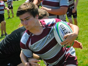 Holy Trinity's Kyle Major carries the ball during the CWOSSA A/AA boys rugby tournament in Waterford on Wednesday. Major and the Titans defeated Erin in the semi-final and will face Paris for the championship on Thursday.
JACOB ROBINSON/Simcoe Reformer