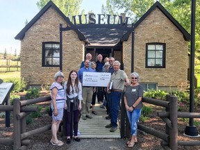 Banff-Cochrane MLA Cam Westhead presents a cheque at the Cochrane Historical Museum to members of the Cochrane Historical & Archival Preservation Society.