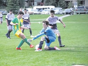 Canmore Collegiate's Max Haubermann is stopped by brave Notre Dame (High River) goaltender during a Foothills High School Soccer League game  on May 23. Russ Ulloyot/Crag & Canyon.