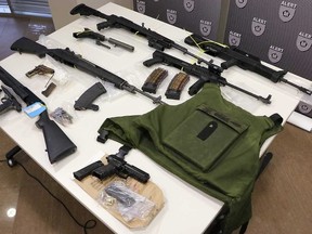 Some of the items seized by ALERT in an investigation into organized crime, displayed in Edmonton, Alta. on Wednesday, May 30, 2018. They include an SKS rifle, Norinco Type 97 a Remington .223-calibre rifle, a shotgun, Norinco M14 and four handguns. A bulletproof vest with ballistic plates, a suppressor and over-capacity magazines were also seized. Supplied Image/ALERT