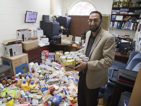 Asad Choudhary, principal of the London Islamic School, sorts donations to the London Food Bank last week, part of a larger food drive by the Muslim community during the holy month of Ramadan. (Derek Ruttan/Postmedia Network)