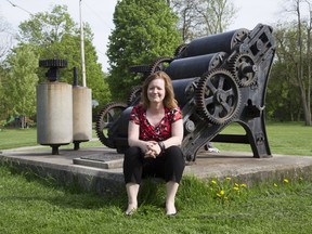 Michelle Hamilton, a public-history professor at Western University, sits beside a decommissioned soap milling machine in Richard B. Harrison Park, where the London Soap and Cosmetics Co. once operated from 1875 to 1984. Some of Hamilton’s students are helping create audio clips about notable sites throughout the city. (Derek Ruttan/Postmedia Network)