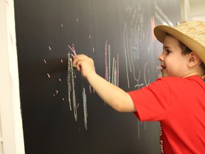 Julian Caporicci puts his artistic talents on display on the Woodstock Art Gallery's chalk board wall. (Chris Funston/Sentinel-Review)